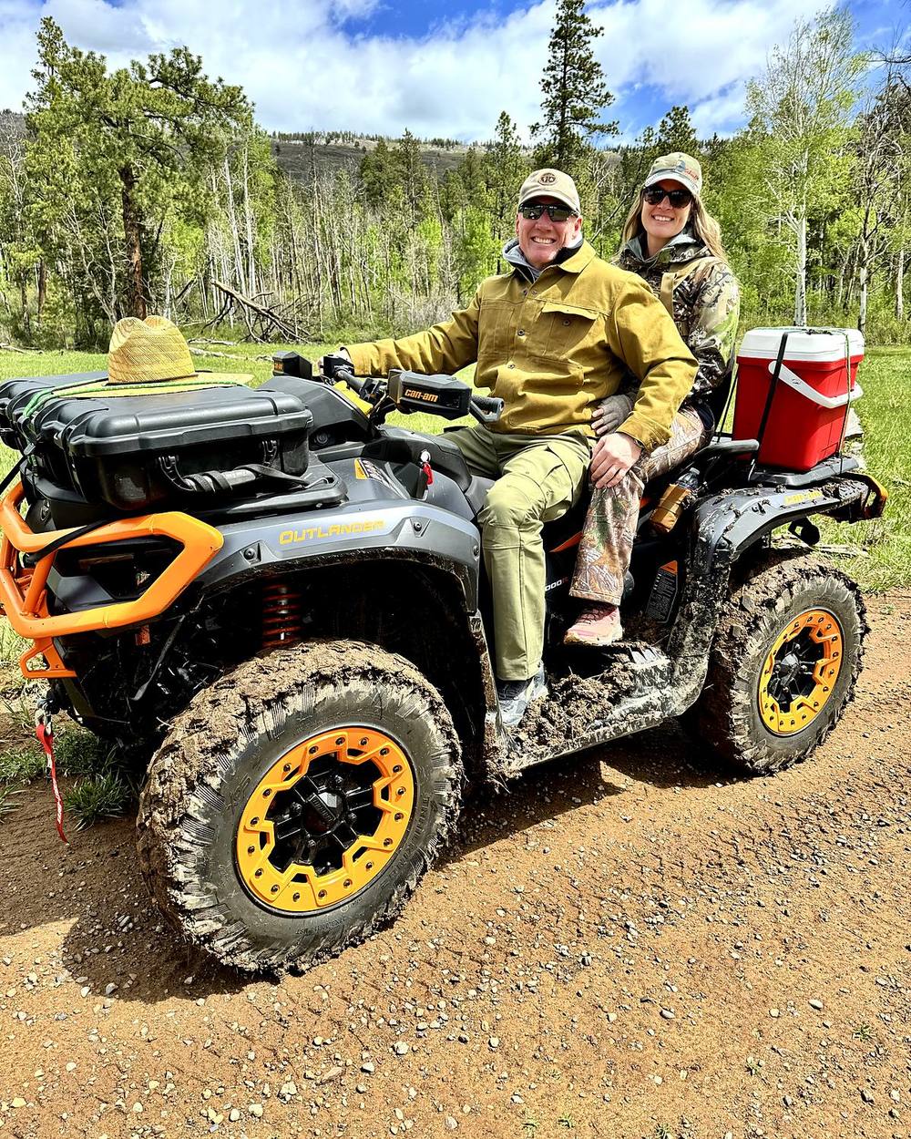 The two of us on a mud-caked ATV on a Colorado trail, cooler strapped to the back, aspens and mountains behind.