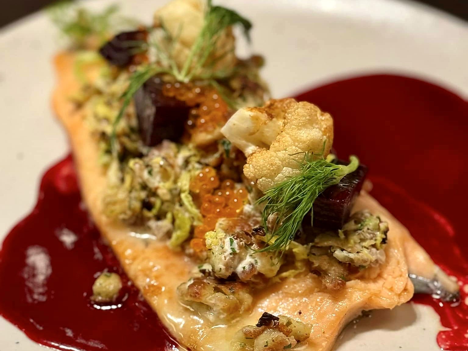 Trout at Acre — a fillet piled with shaved brussels sprouts, trout roe, roasted cauliflower, and beets over a sweep of beet purée.