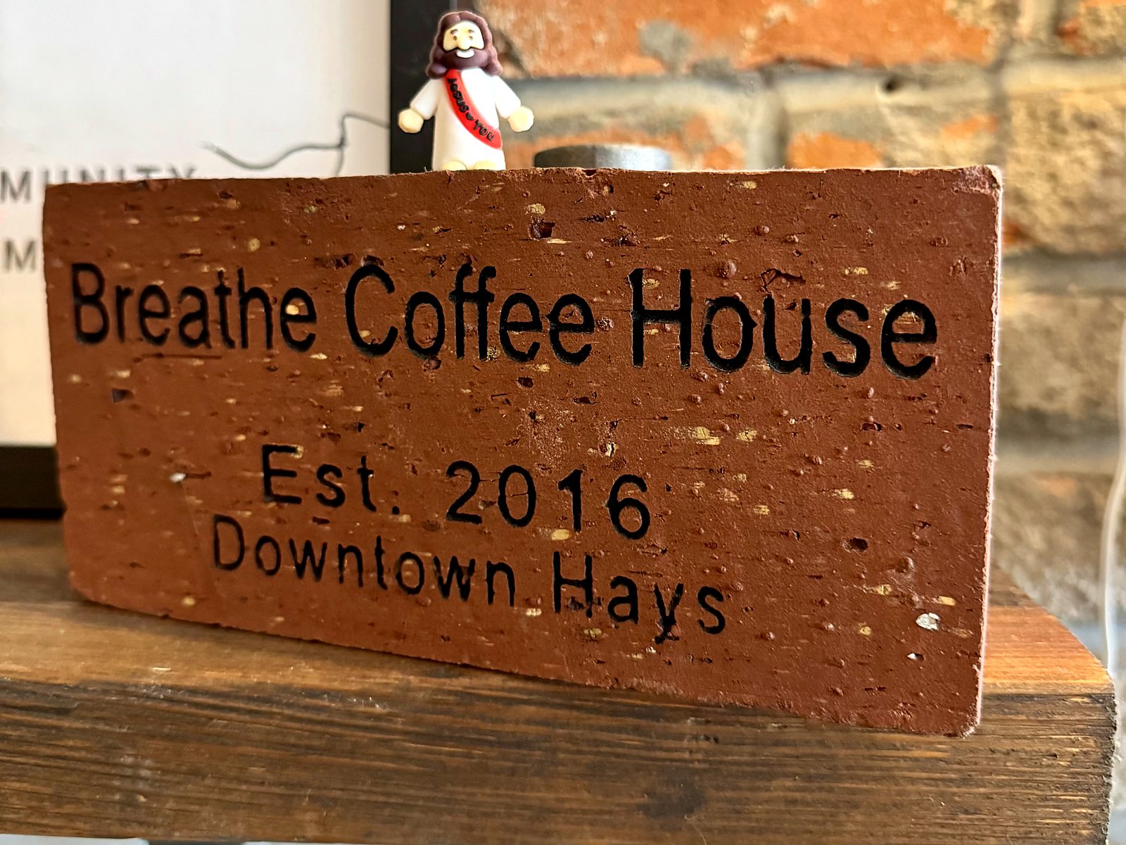 An engraved brick at Breathe Coffee House reading &ldquo;Breathe Coffee House, Est. 2016, Downtown Hays.&rdquo;