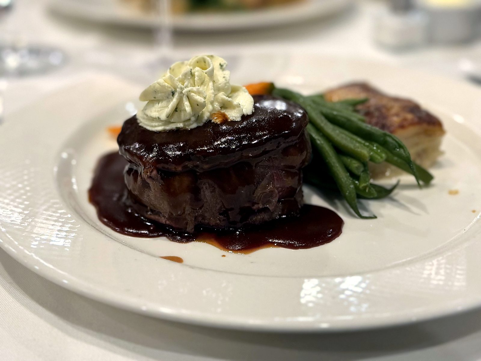 Filet mignon at Café Provence in a glossy red-wine sauce, crowned with herb butter, with haricots verts and potato gratin.
