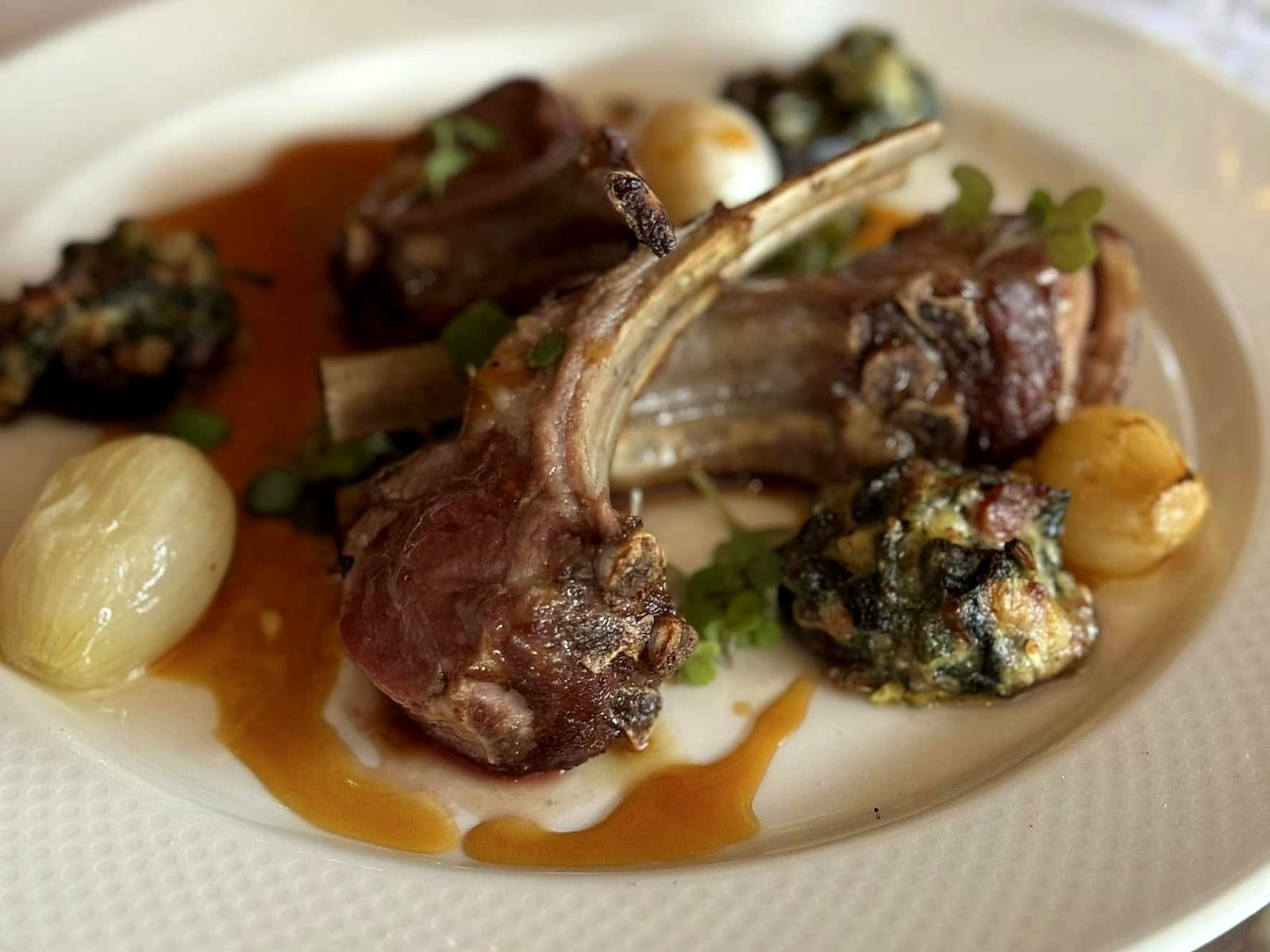 Lamb chops at Café Provence with pearl onions, creamed-spinach-stuffed mushroom caps, and jus.