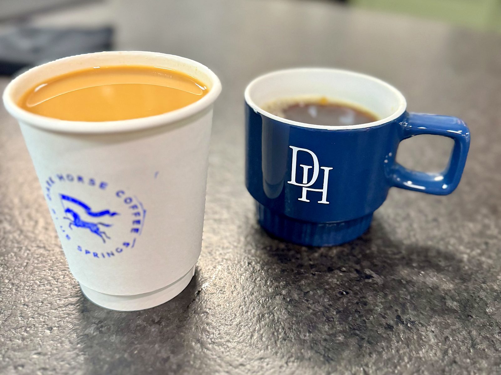 Two coffees at Dark Horse — one poured light with milk, one black.