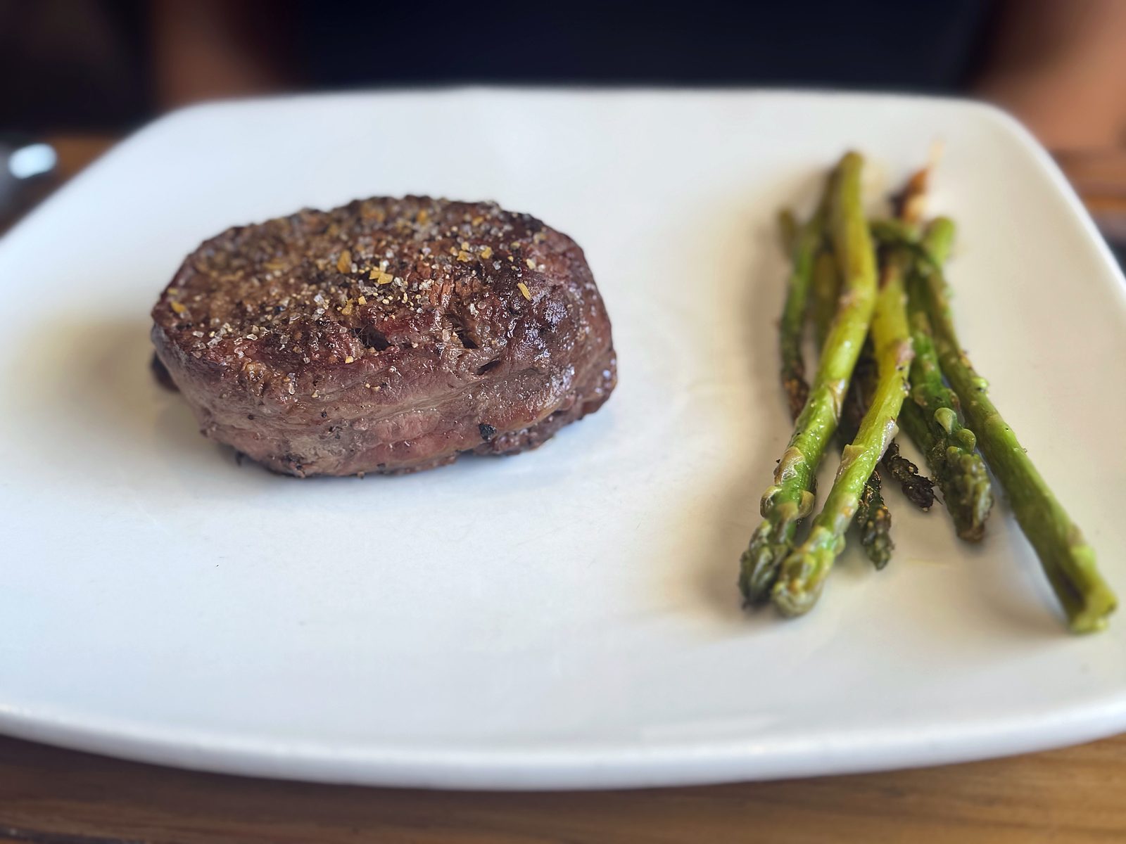 A hand-cut filet at Hickok&rsquo;s — thick, seasoned, and seared, with roasted asparagus alongside.