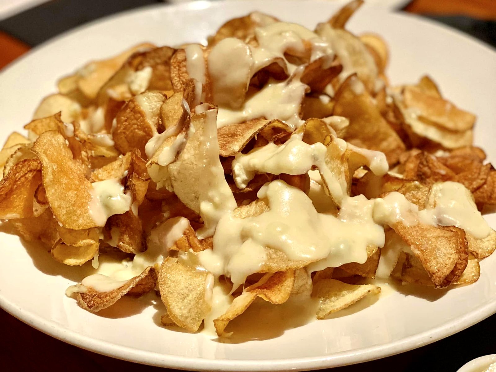 The Blue Cheese Potato Chips at J. Gilbert's — a mountain of hand-cut chips draped in warm blue cheese sauce.