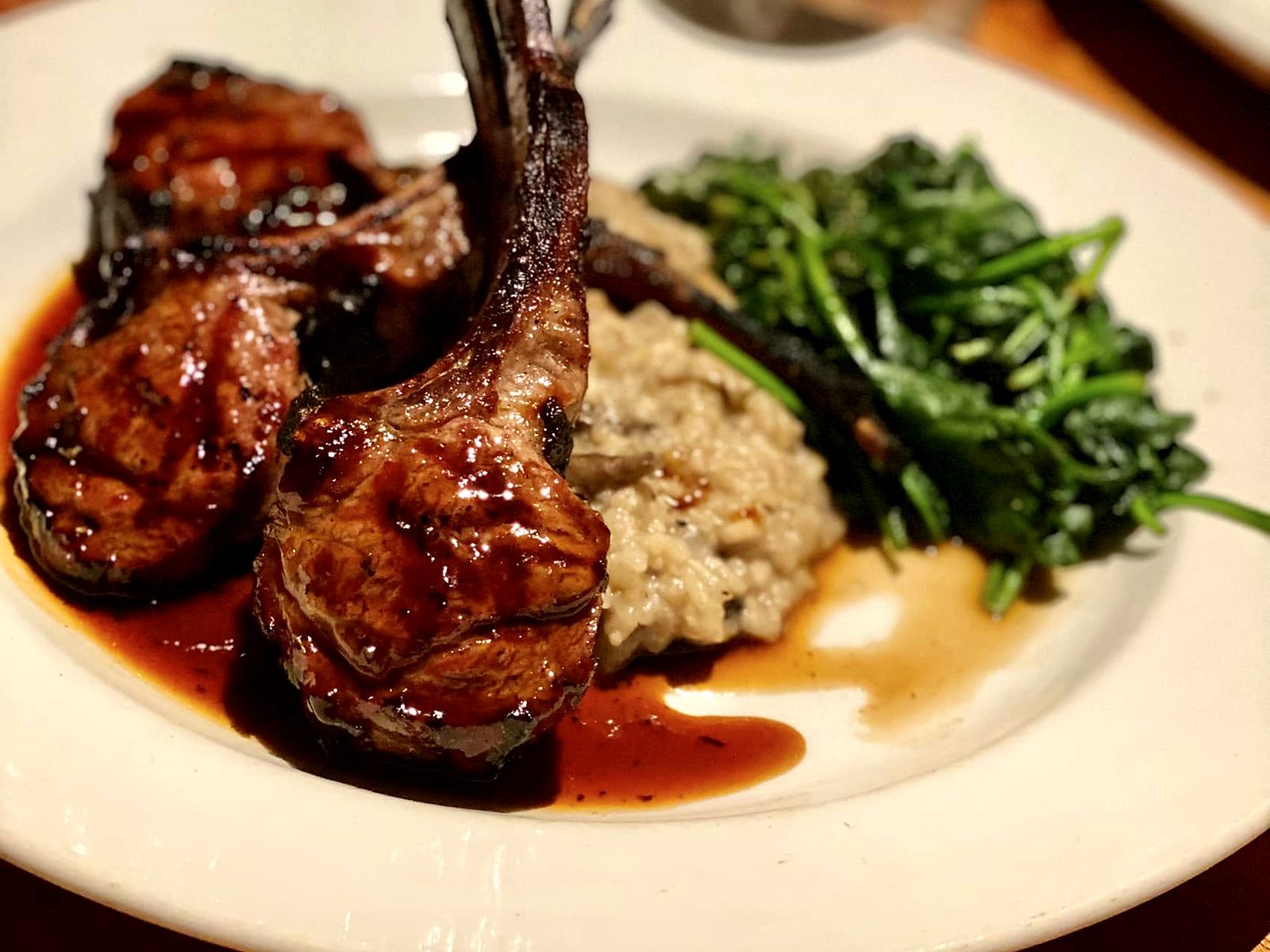 Glazed lamb lollipops at J. Gilbert's — chops crossed over mushroom risotto with sautéed broccolini.