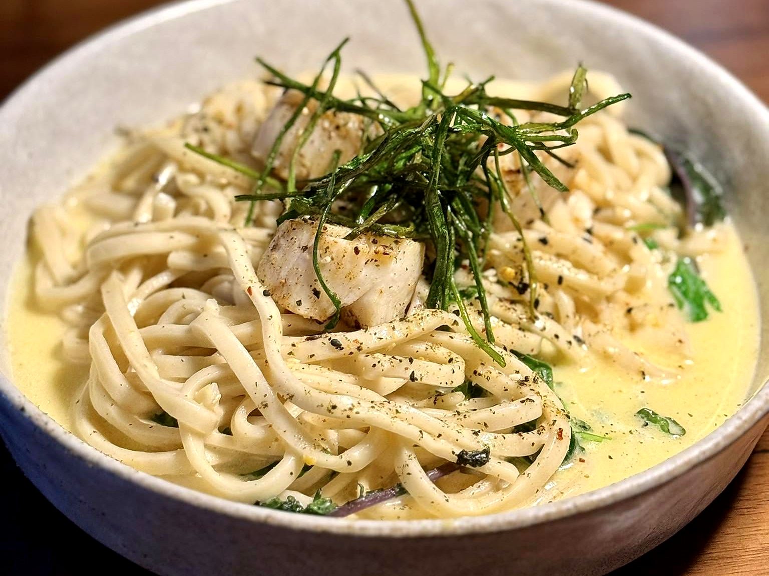 The scallop pasta at Noka — seared scallops tangled in noodles and cream sauce, topped with a nest of crisped seaweed.