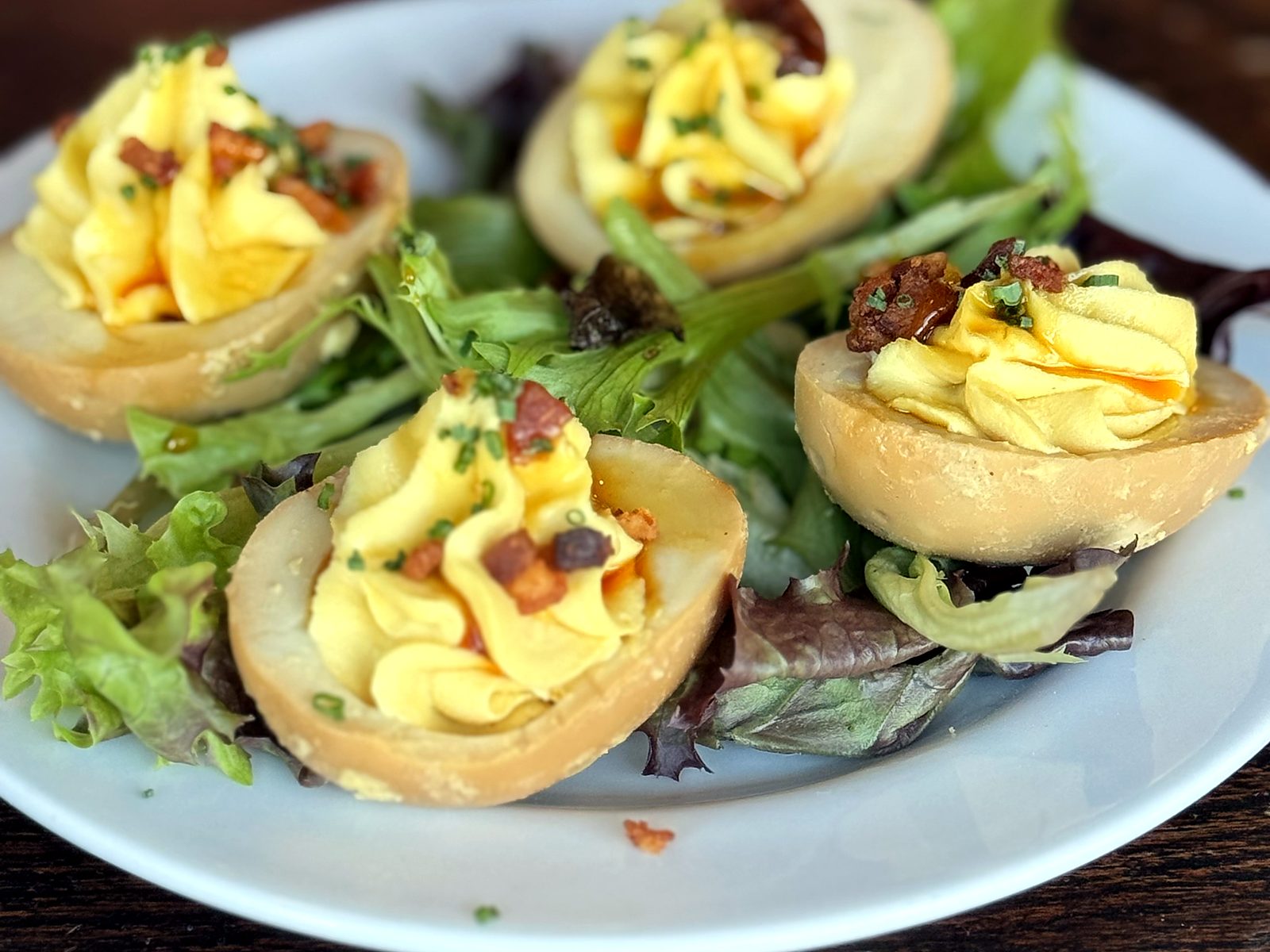 Bacon pickled deviled eggs at The Pullman, piped high and drizzled with hot honey over greens.