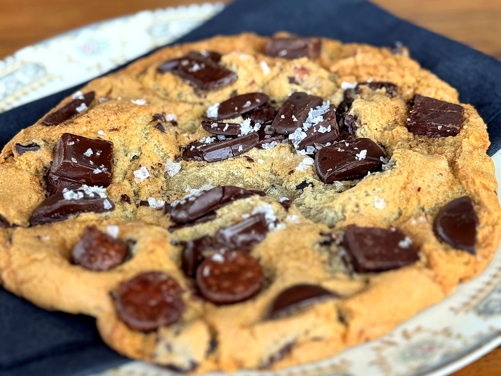 A chocolate chunk cookie at The Russell, scattered with flaky salt, served on vintage china.