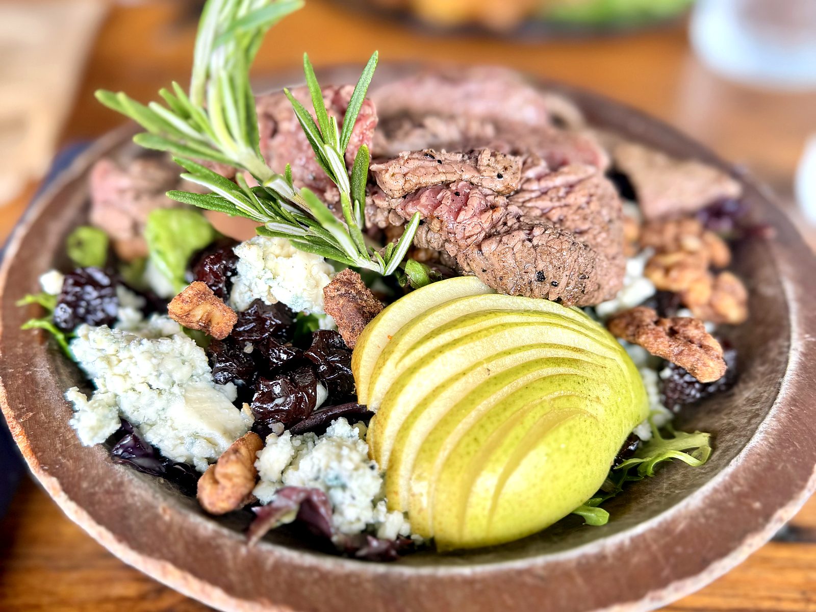 The green pear salad with steak at The Russell — sliced steak over greens with a fanned pear, blue cheese, dried cherries, and candied walnuts.