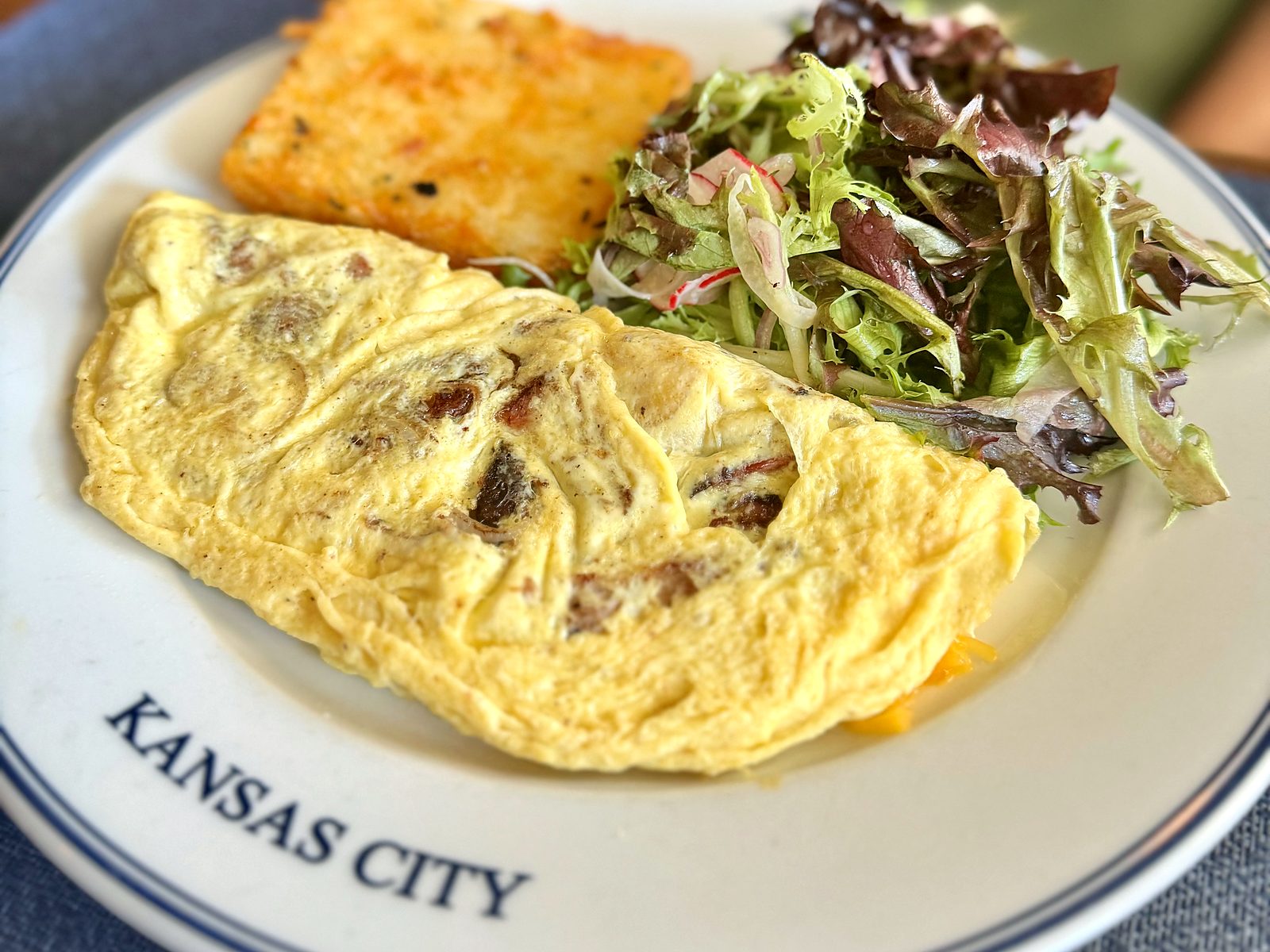 A pulled pork omelette at Rye with a crisp hash brown square and dressed garden greens.