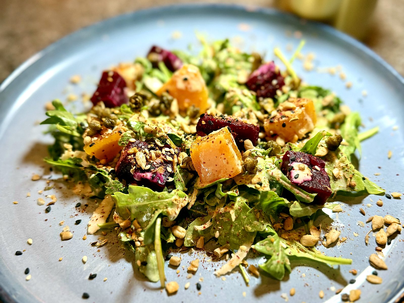 The beet salad at Scratch — red and gold beets over arugula with fried capers, toasted seeds, and a creamy dressing.