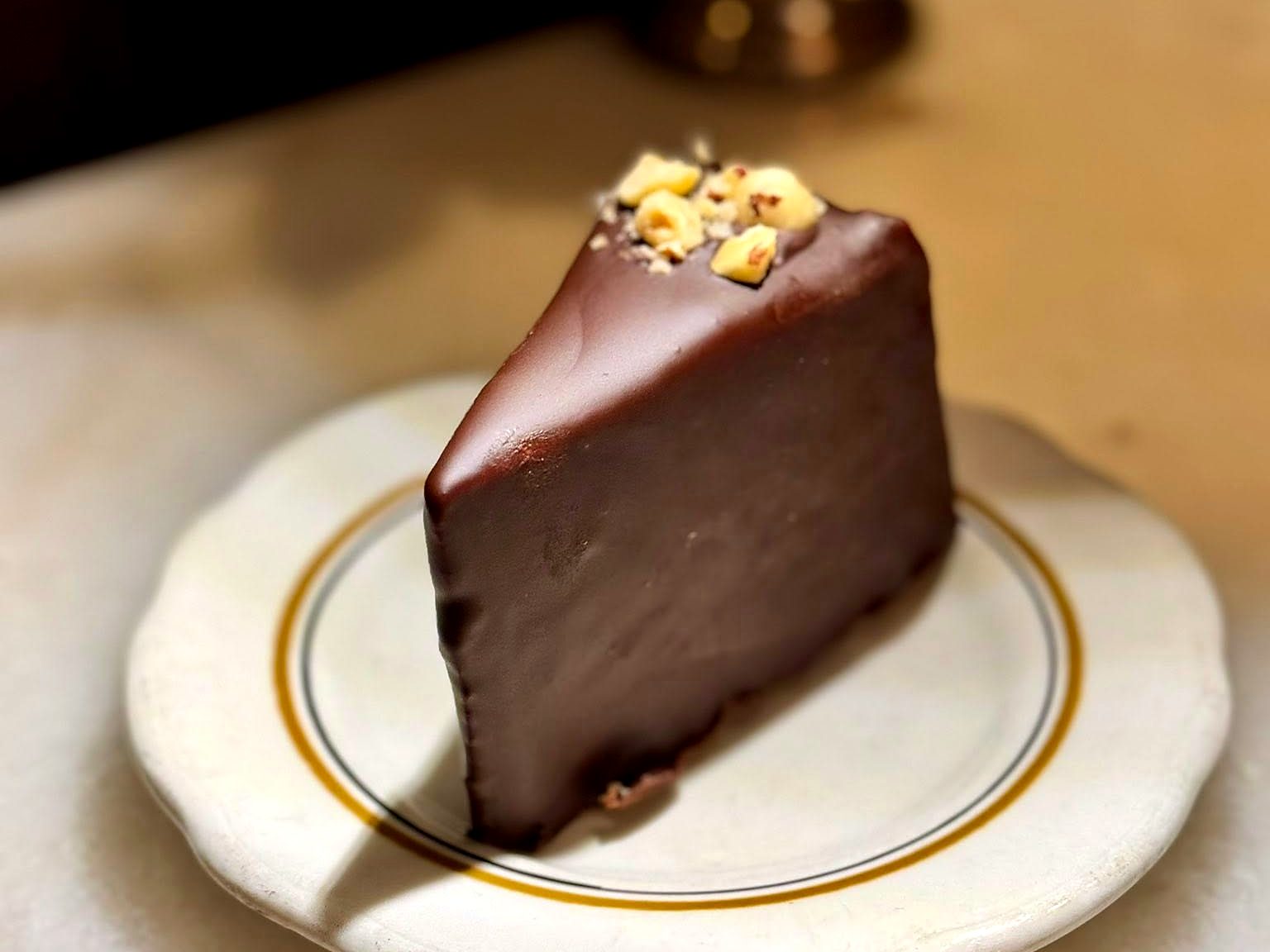 A chocolate-glazed cake wedge at Tailleur, crowned with crushed hazelnuts.