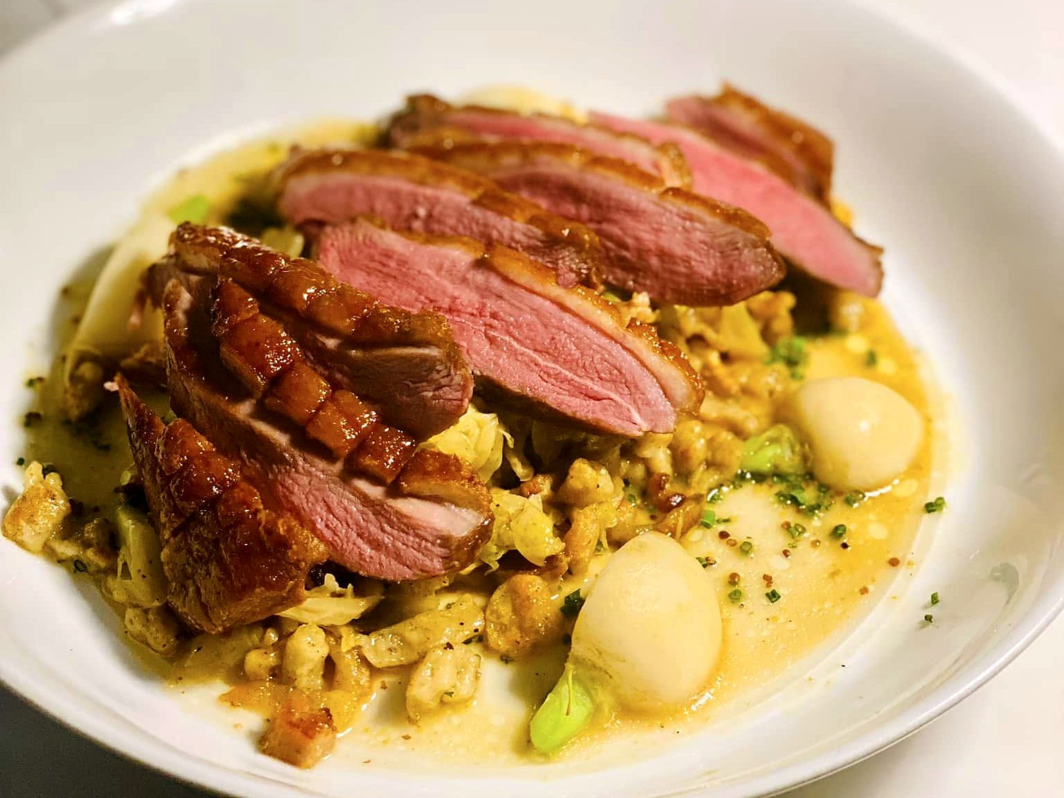 Another duck breast at Verbena — crisp-scored skin over braised cabbage and spaetzle with pearl onions in a golden jus.