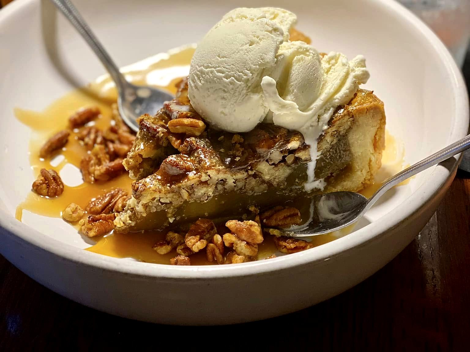 Pecan pie at Wilder’s — a deep slice under two scoops of vanilla ice cream, with caramel and toasted pecans.