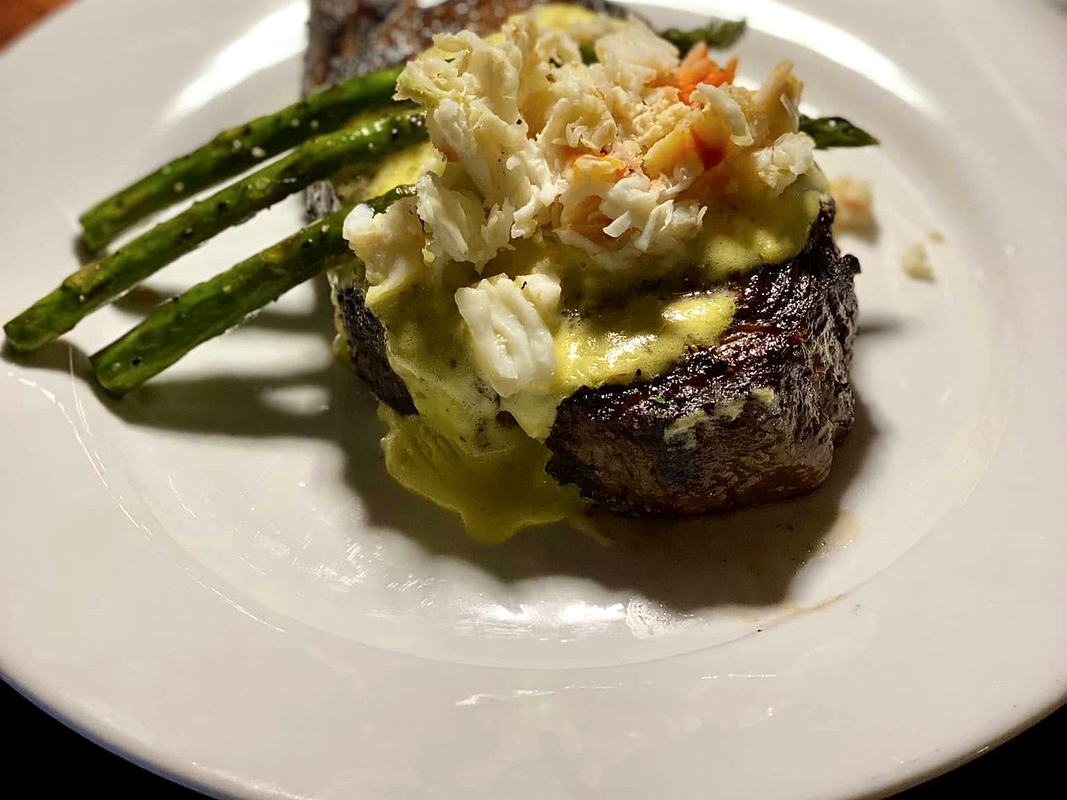 The Steak Oscar at Wilder’s — center-cut filet under king crab and béarnaise, grilled asparagus leaning alongside.